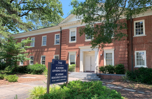 Image of Academic Advising Center Building. Red-brick, colonial building with trees.